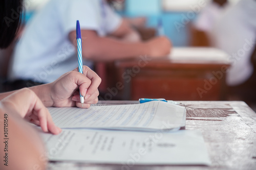 Student doing test or exam  in classroom of school with stress