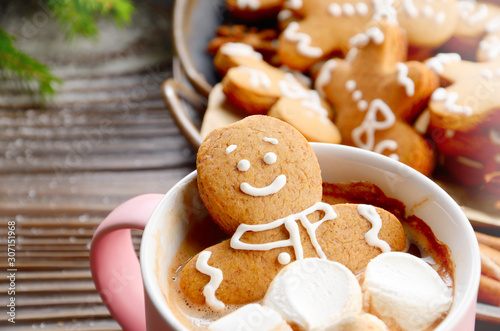 Pink mug with hot chocolate marshmallows and gingerbread man closeup