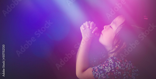 Little girl praying on the bed in the night time at home.Little asian girl hand praying for thank GOD,Hands folded in prayer concept for faith,spirituality and religion.
