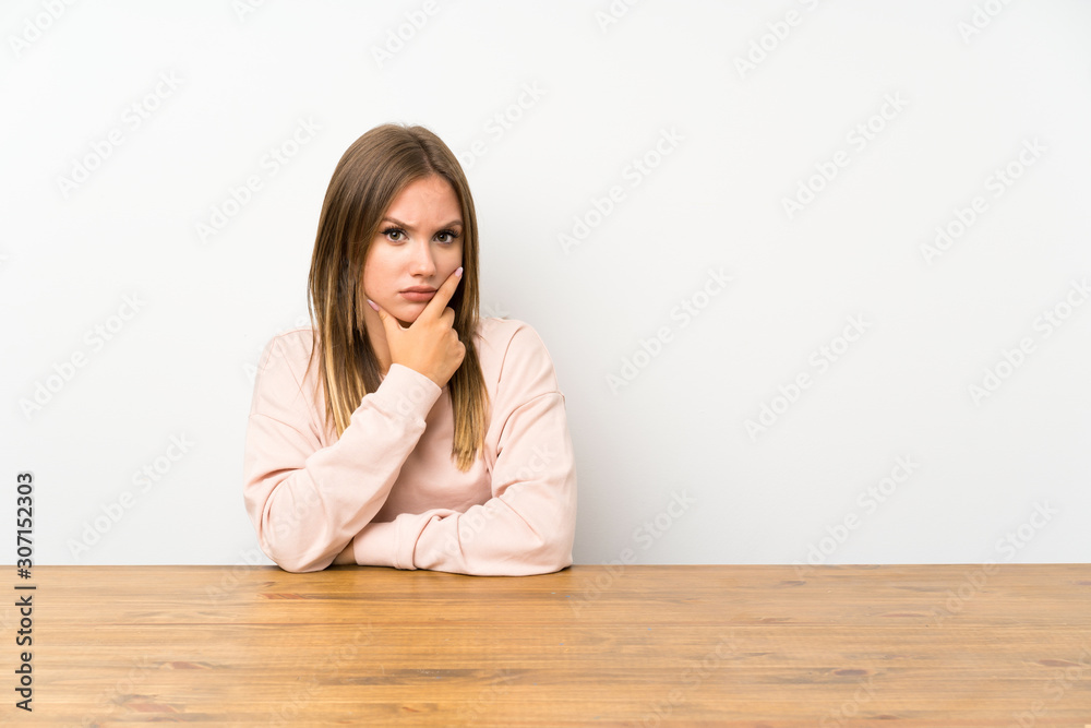 Teenager girl in a table thinking an idea Teenager girl in a table thinking an idea
