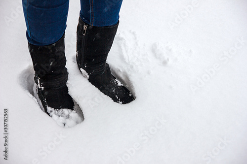  Feet in boots in the fresh snow. Winter season. Snowy weather.