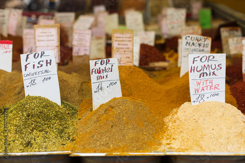 Different colorful spices on display in Carmel Market in Tel Aviv, Israel. Spices for fish, for falafel, for humus and other dishes in Israeli street market photo