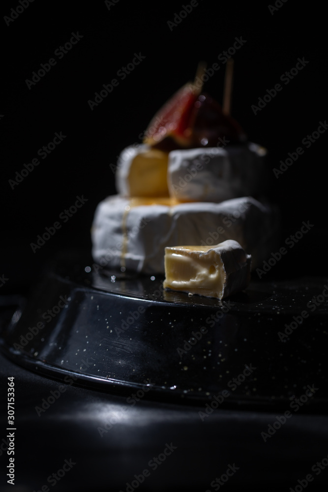 Close-up halfs of figs and cheese with honey on the black background Close-up halfs of figs and cheese with honey on the black background