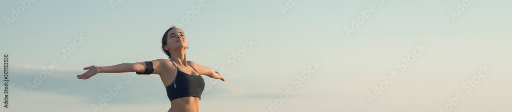 Plakat Młoda szczupła wysportowana dziewczyna w odzieży sportowej z nadrukami skóry węża wykonuje zestaw ćwiczeń. Fitness i zdrowy styl życia.