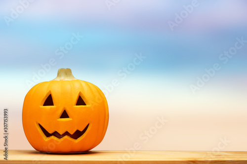 Halloween holiday concept.Jack o lantern pumpkin on black background decor on wooden table with starry night light.Copy space. © MIA Studio