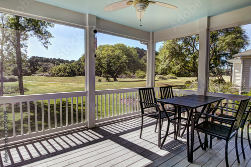 Three season screen porch with view out onto golf course and park. photo