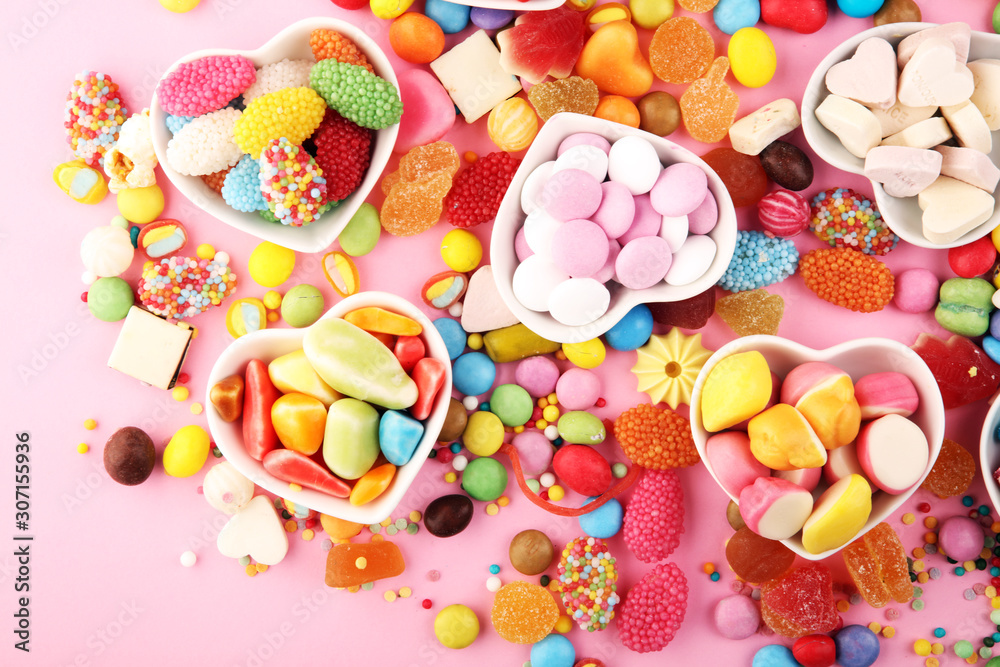 candies with jelly and sugar. colorful array of different childs sweets and treats on pink background candies with jelly and sugar. colorful array of different childs sweets and treats on pink background
