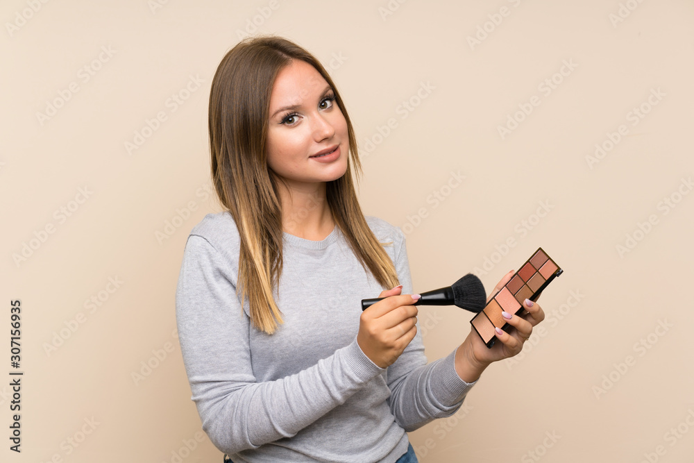 Teenager girl with makeup palette over isolated background Teenager girl with makeup palette over isolated background