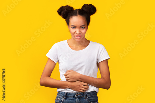 Young african american woman suffering from stomach pain