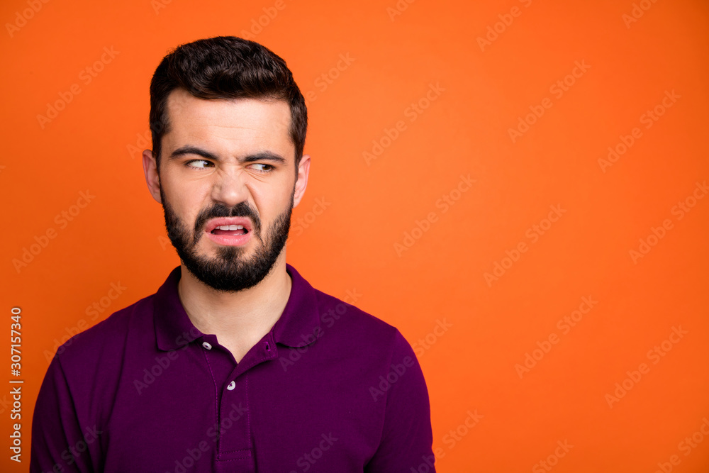 Close up photo of sad upset guy look copyspace dislike view scent he smell grimace frown face wear stylish clothes isolated over orange color background Close up photo of sad upset guy look copyspace dislike view scent he smell grimace frown face wear stylish clothes isolated over orange color background