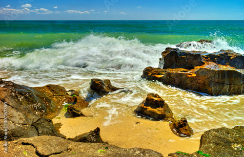 Beautiful landscape with rocks and sea waves on a sunny beach