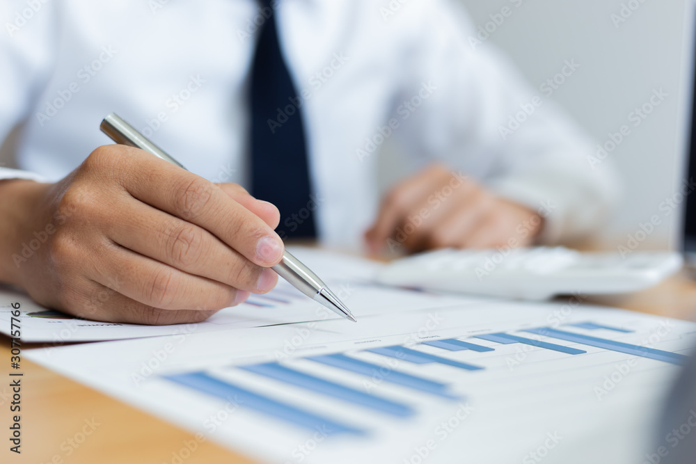 Business men analyze financial data for the company's revenue with graphs and calculators, accounting concept Business men analyze financial data for the company's revenue with graphs and calculators, accounting concept
