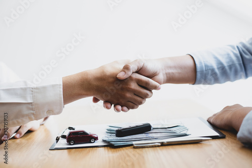 Car dealership closed the sale and shook hands with customers to congratulate. , Automotive business concept