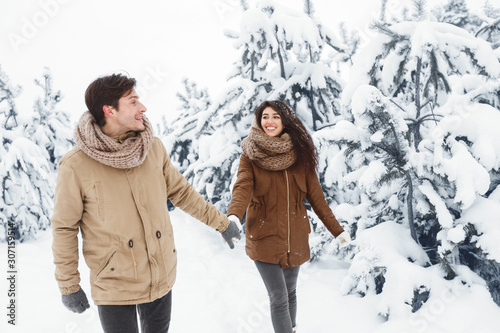 Happy Spouses Walking Holding Hands Through Winter Forest