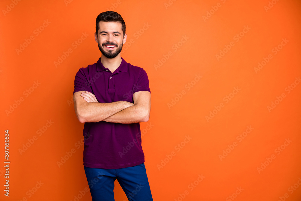 Portrait of charming guy have summer weekends cross hands enjoy free time wear modern good looking clothing isolated over orange color background Portrait of charming guy have summer weekends cross hands enjoy free time wear modern good looking clothing isolated over orange color background