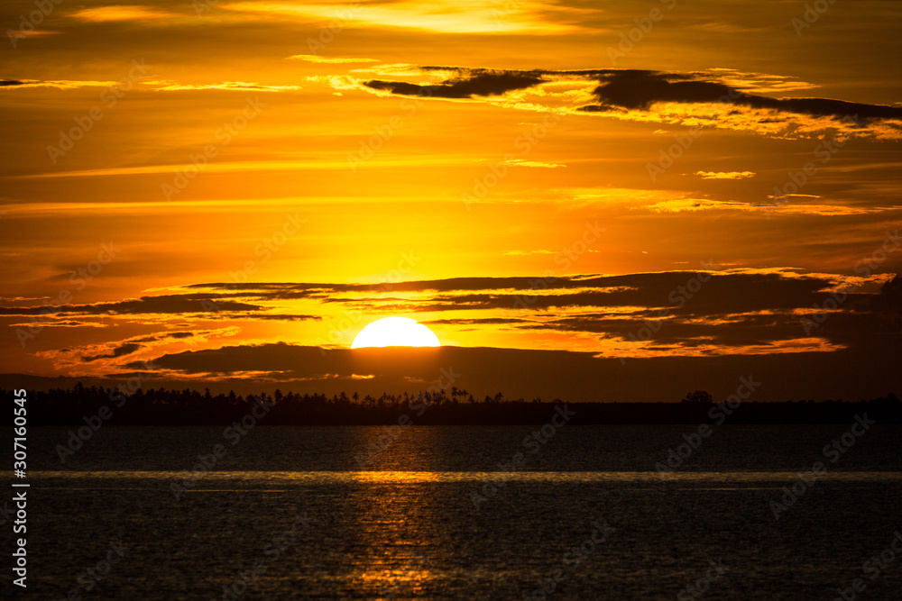 Spectacular golden sunset sky with illuminated clouds, coast of Zanzibar