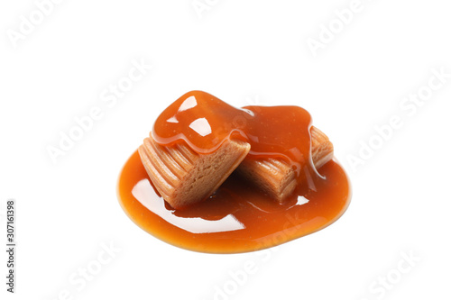 Caramel candies with sauce isolated on white background