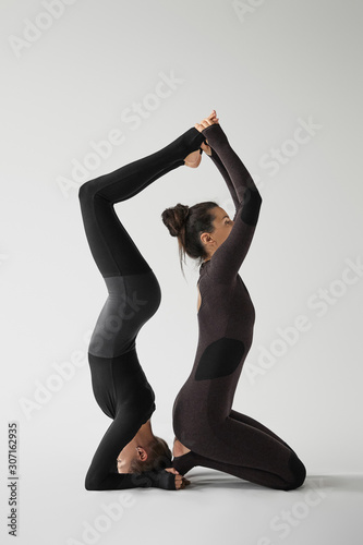Young women in sportswear practicing acroyoga