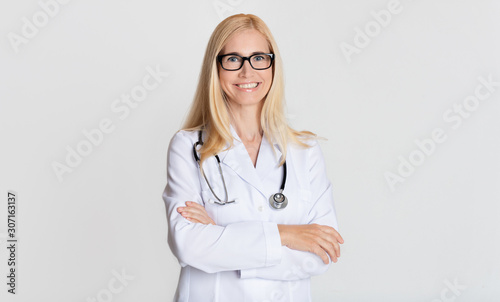 Smiling medical physician doctor posing on grey background