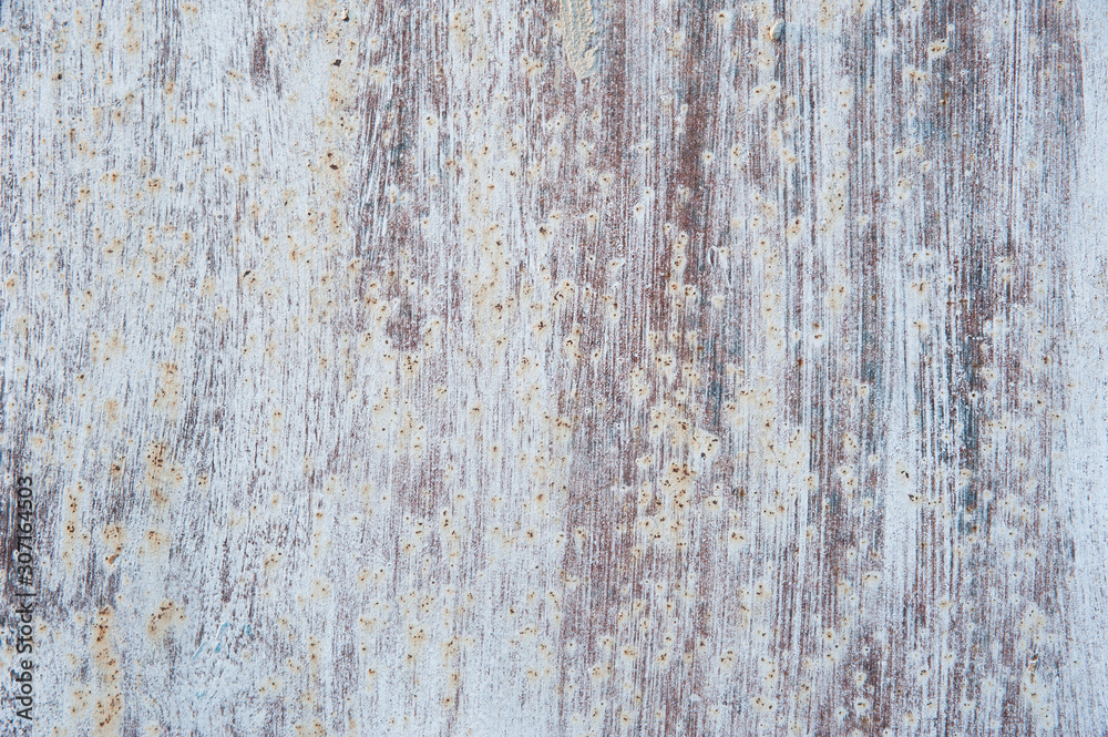 Streaks of white paint and rust stains on the old, brown, tattered metal surface. Abstract background, texture.