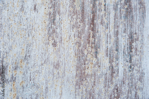 Streaks of white paint and rust stains on the old, brown, tattered metal surface. Abstract background, texture.