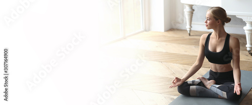 Relaxed young woman practicing yoga at dance studio