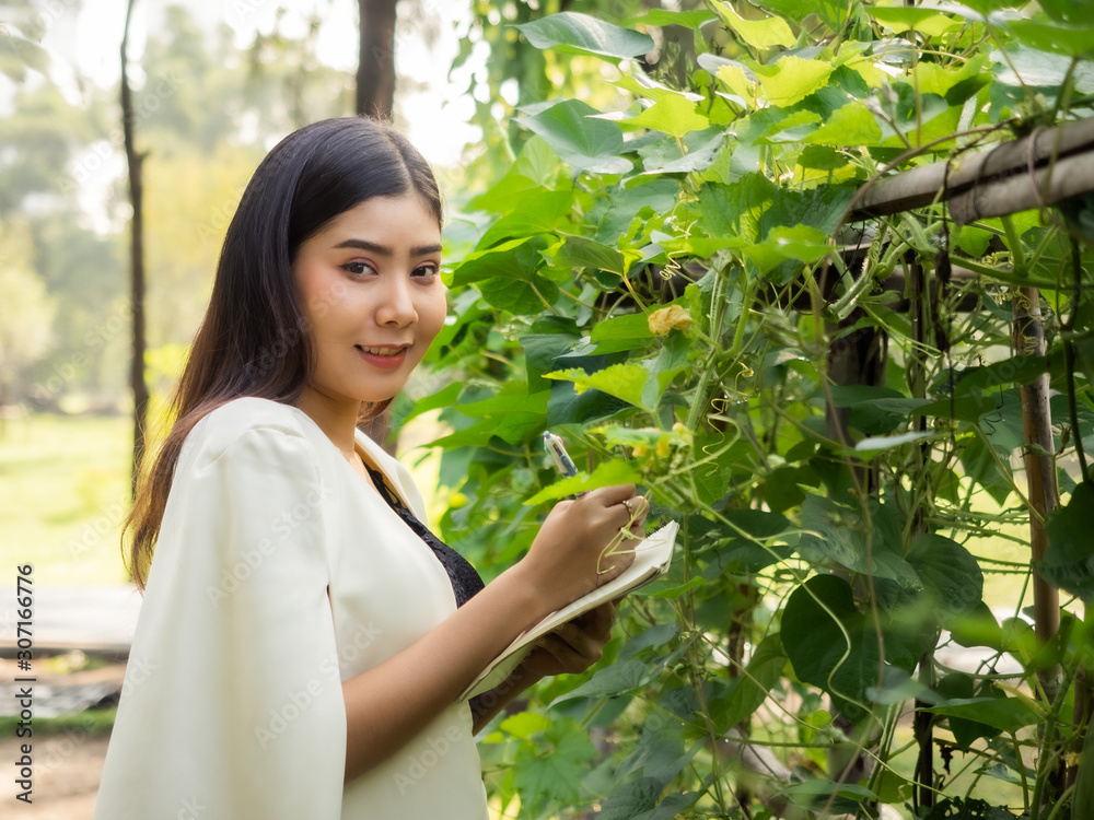 beauty asia business woman farmer holding pen and checklist note plate in organic farm copy space
