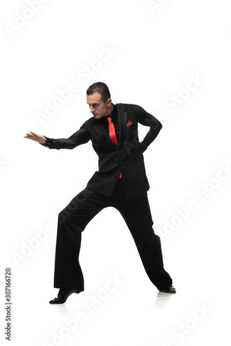 passionate tango dancer in elegant black suit inviting to dance on white background