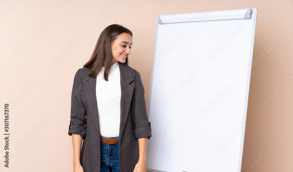 Young woman giving a presentation on white board looking side Young woman giving a presentation on white board looking side