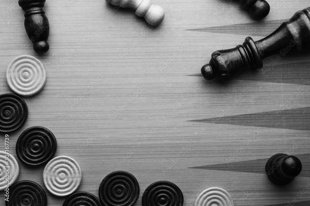 chess and checkers made of wood on a game board black and white colors