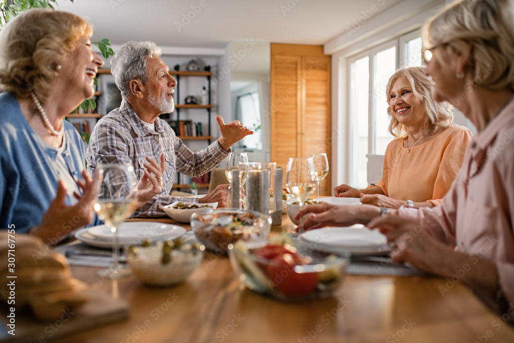 Happy mature people communicating while enjoying in lunch in dining room. Happy mature people communicating while enjoying in lunch in dining room.
