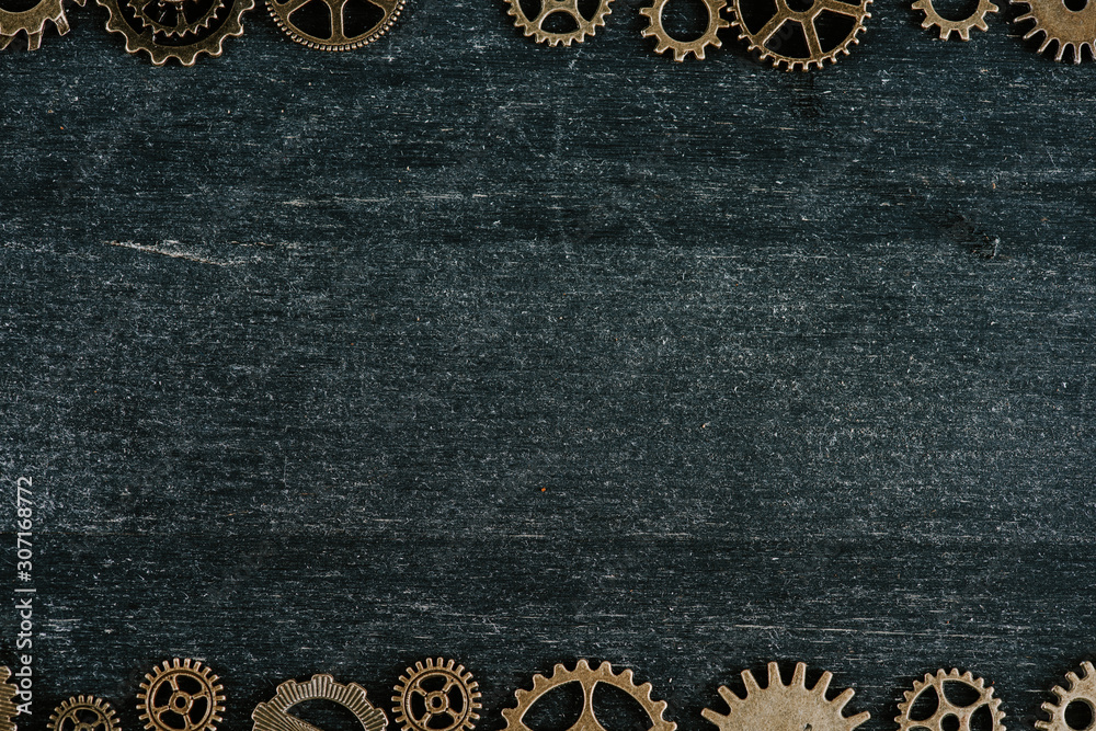 borders of vintage metal gears on dark wooden background with copy space