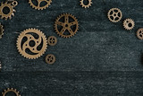 top view of vintage metal gears on dark wooden background with copy space