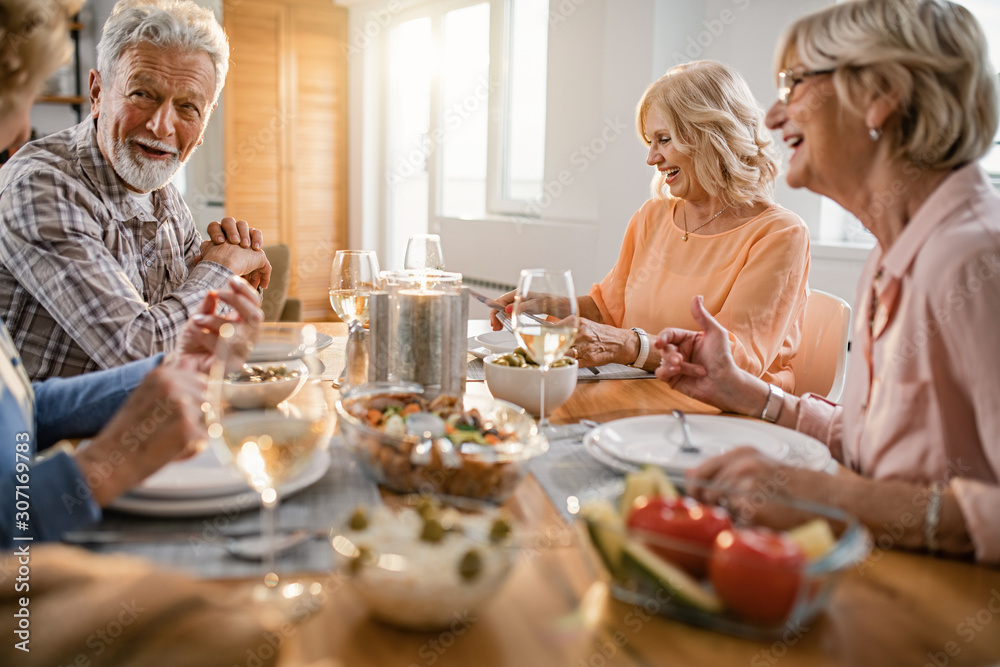 Happy seniors enjoying in conversation during lunch time at dining table. Happy seniors enjoying in conversation during lunch time at dining table.