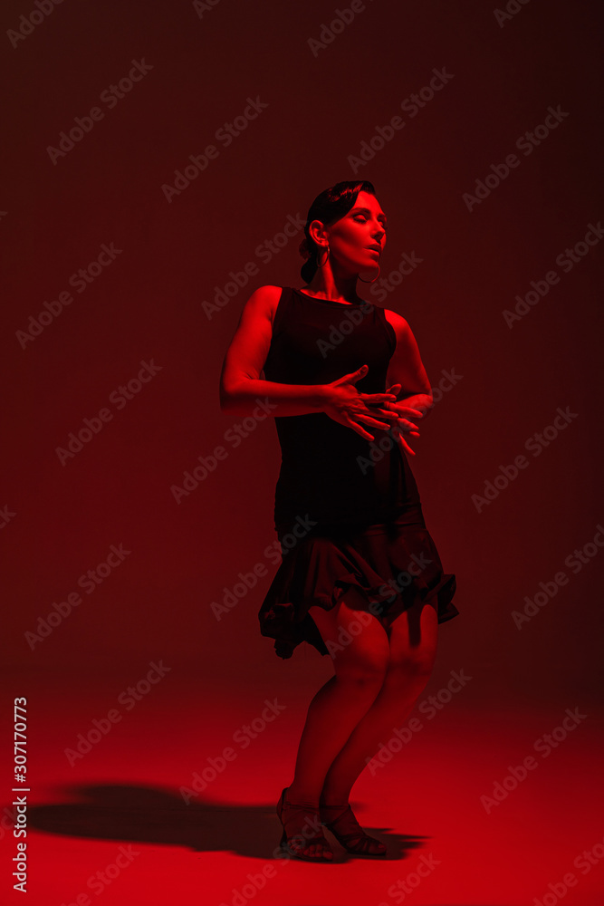 passionate dancer in black dress performing tango on dark background with red lighting passionate dancer in black dress performing tango on dark background with red lighting