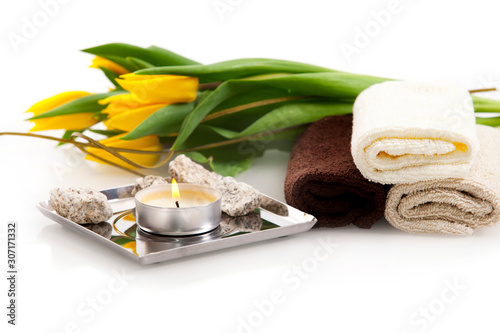 Brown face towels and yellow tulips on white background