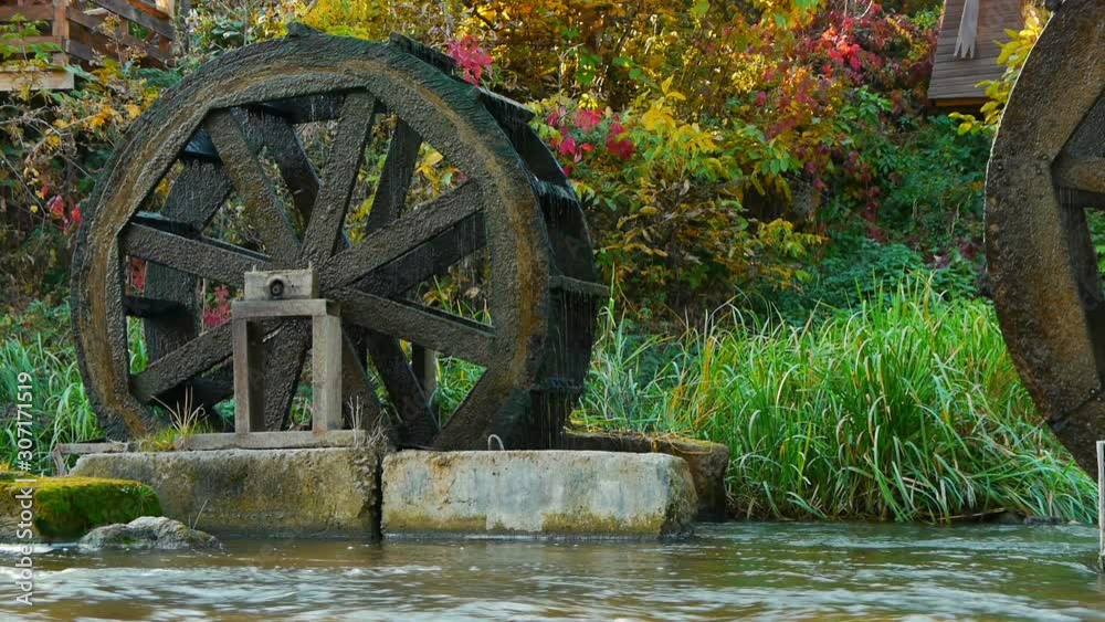 Old antique water mills on river. Turning from power of a water stream. Old antique water mills on river. Turning from power of a water stream.