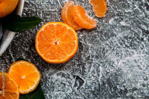 Ripe cut tangerine closeup on gray table © elenavah