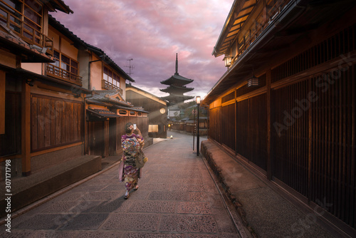 Photography Kyoto, Japan - November 4 2018: A woman dressed like a Maiko taking a photo of Yasaka Pagoda with sun rays at sunrise in Higashiyama-ku, a traditional street in Gion district, Kyoto