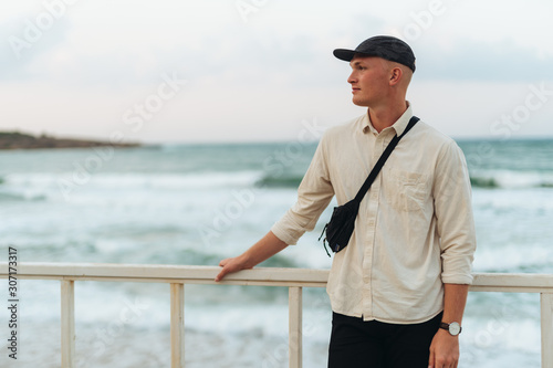 Young man in hat by the sea photo