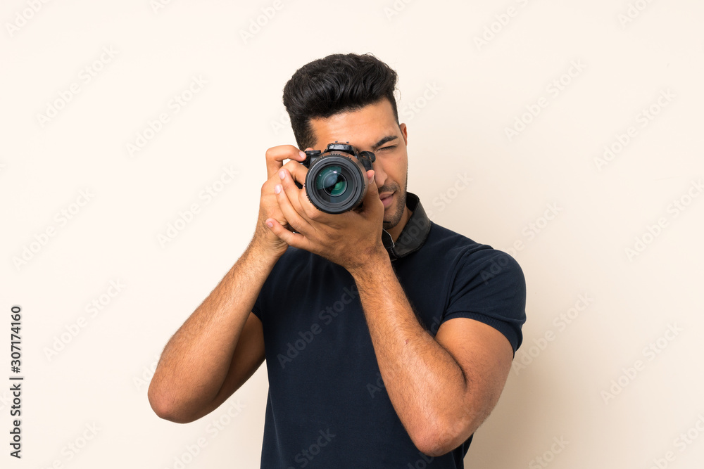 Young handsome man over isolated background with a professional camera Young handsome man over isolated background with a professional camera