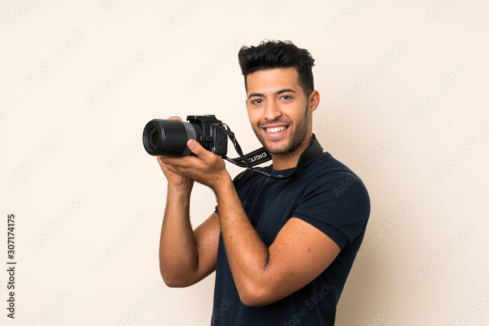 Young handsome man over isolated background with a professional camera Young handsome man over isolated background with a professional camera