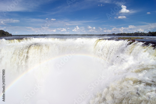 View of Devil`s Throat With Rainbow Against Blue Sky and At Iguazu Falls, Argentina