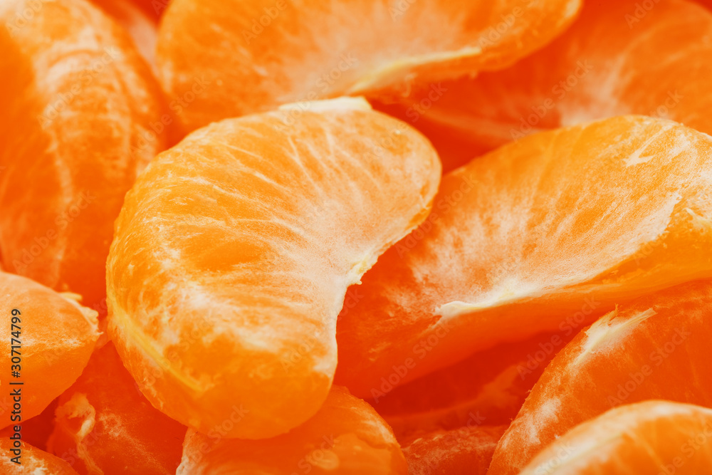 Slices of juicy tangerines close up as background texture.