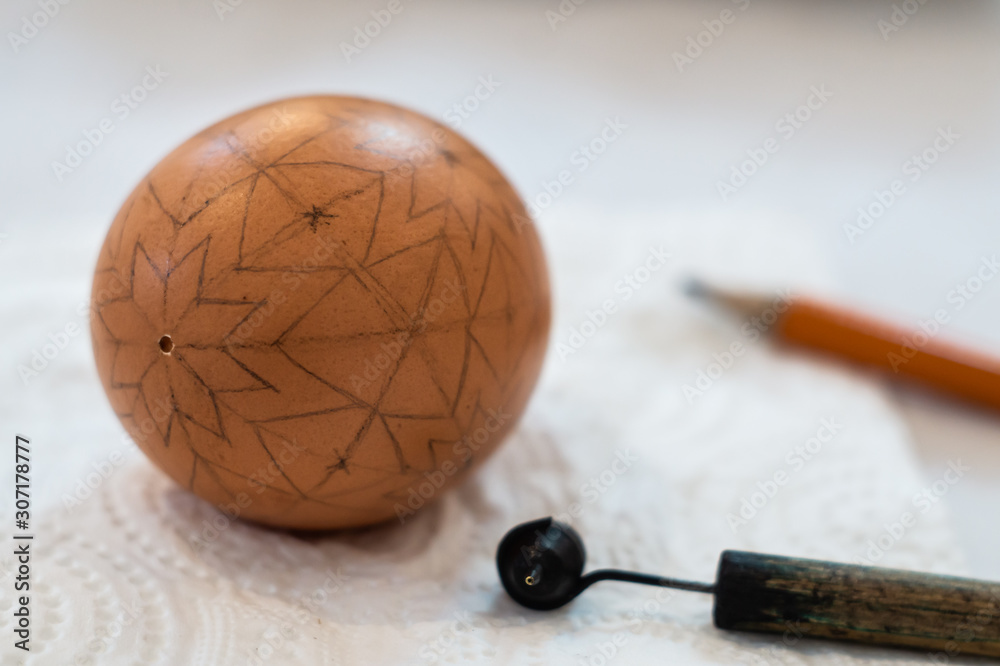 Easter egg with a marking pencil for traditional painting