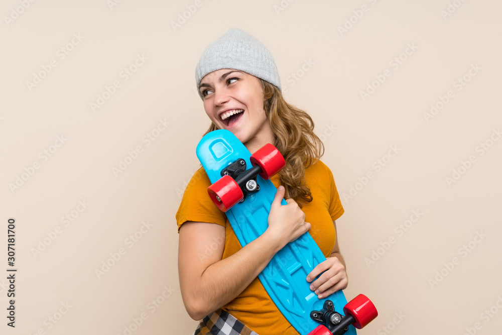 Young skater blonde girl over isolated background Young skater blonde girl over isolated background