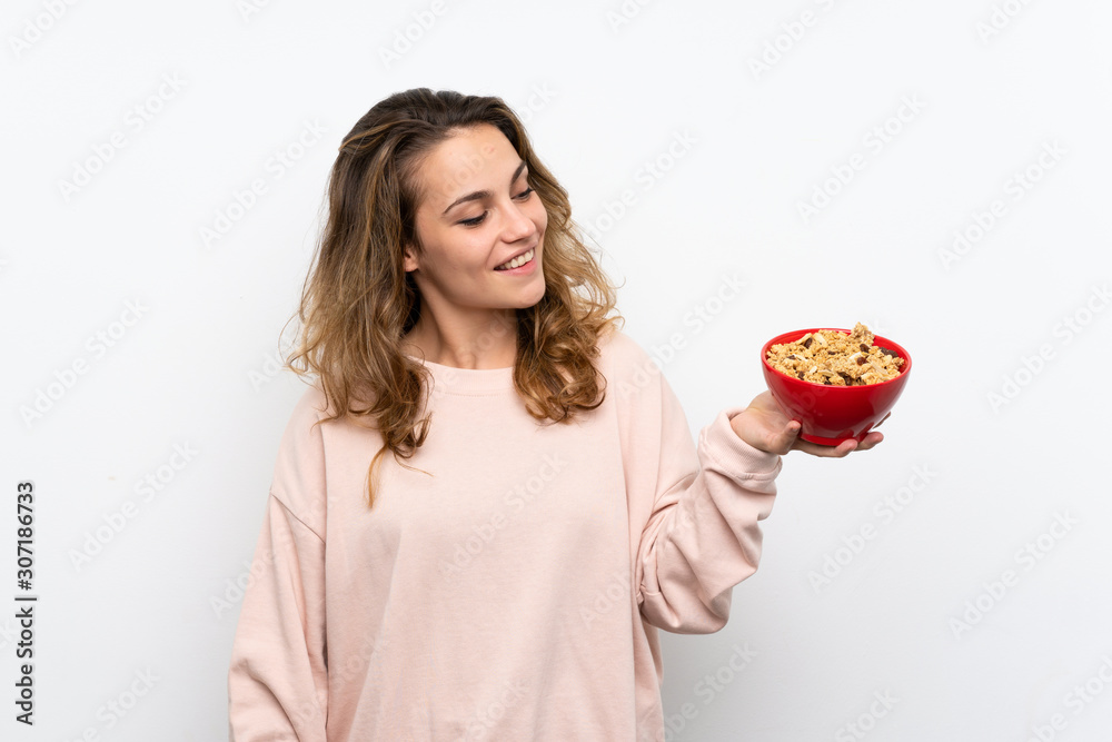 Young blonde woman holding a bowl of cereals Young blonde woman holding a bowl of cereals