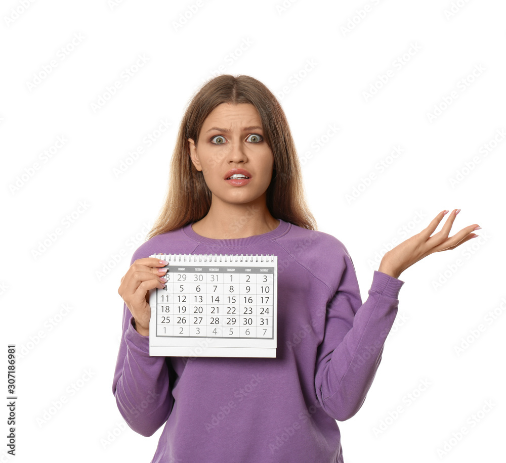 Emotional young woman holding calendar with marked menstrual cycle days on white background