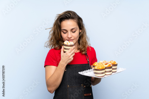 Young blonde woman holding mini cakes