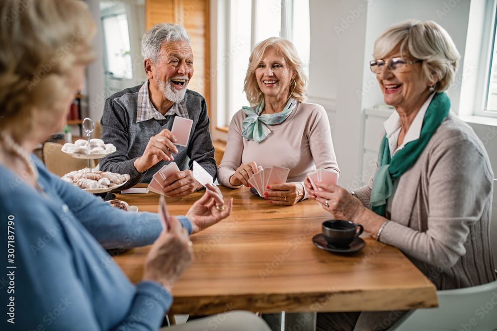 Group of cheerful seniors playing cards during coffee time at home. Group of cheerful seniors playing cards during coffee time at home.